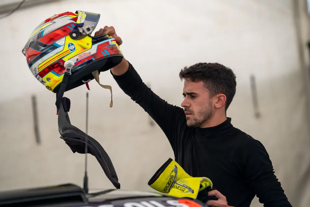 Driver holding his helmet in the garage